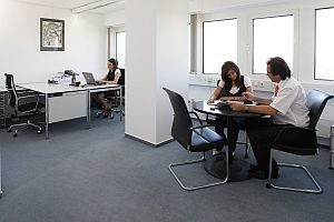 Abbildung: Sitzende Mitarbeiter an ihren Schreibtischen